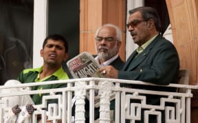 Pakistan manager Yawar Saeed (right), Assistant Manager Shafqat Rana and Kamran Akmal (left) reading the News of the World on the team's dressing room balcony after it broke the match fixing scandal during the final Test Match against England at Lord's in 2010.