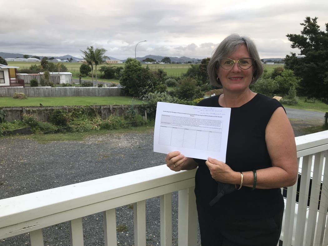 Local resident and airport neighbour Catherine Street with the group's petition to stop Northland's emergency rescue helicopter base shifting to Onerahi airport (seen in photo background)