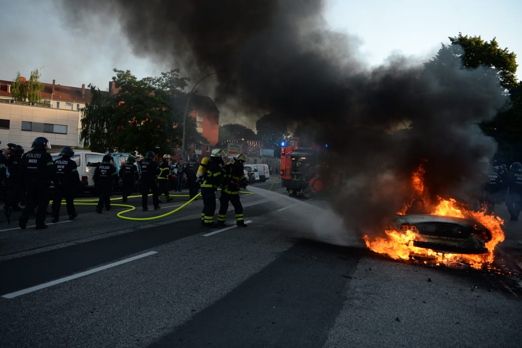 THe fIRe brigade put out a car set alight during the "Welcome to Hell" rally against the G20 summit in Hamburg, northern Germany.