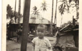 Earliest picture of Alan taken in village, Kampong Dollah in Kuala Lumpur. Alan is seated on the stump of a coconut tree that had fallen (usually in a storm).