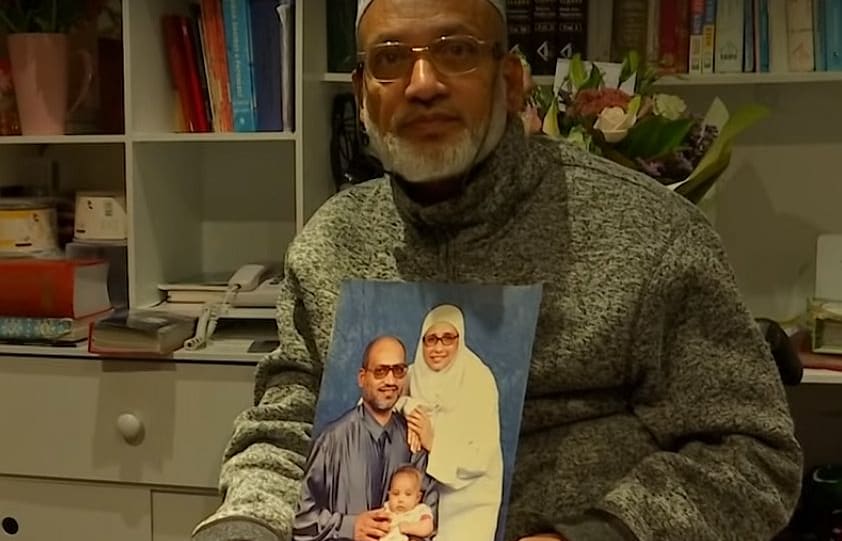Farid Ahmed holds a picture of his family