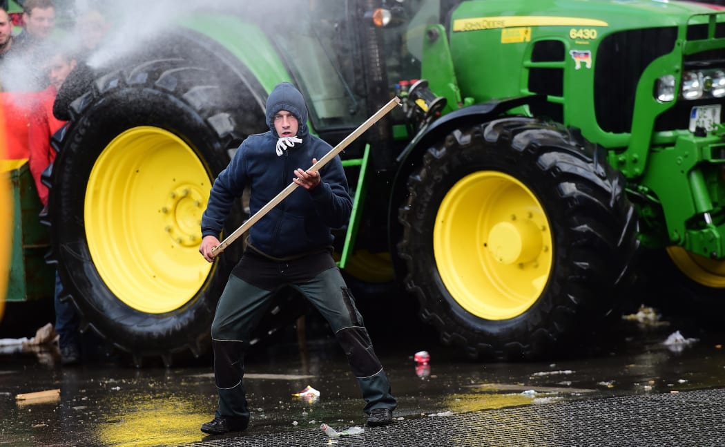 A demonstrator faces anti-riot policemen during a demonstration of farmers in front of the European Commission building on 7 September, 2015, in Brussels.