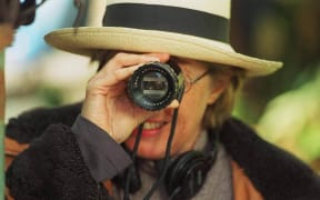 Gaylene Preston looking through a viewfinder lens