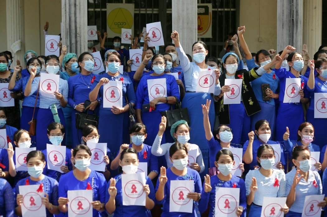 Myanmar university teachers make the three finger salute with red ribbons on their uniform during a ''Civil Disobedience Campaign'' against military coup at Yangon University of Education in Yangon, Myanmar on February 5, 2021.