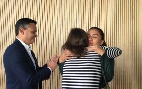 Julie-Anne Genter hugs Marama Davidson while James Shaw looks on