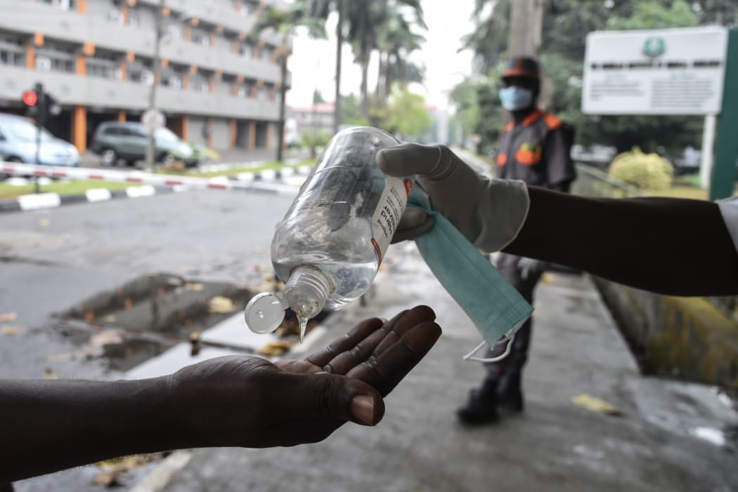 A visitor tries to sanitise hands before being allowed into a state hospital at Yaba in Lagos.