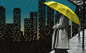Person at bus stop in rain, holding umbrella