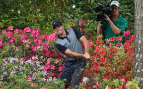 Rory McIlroy hits from the azaleas on the 13th hole in the second round of the 2014 Masters Tournament.