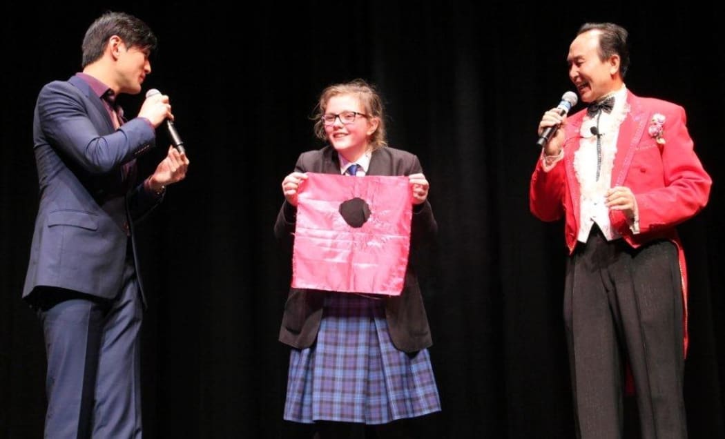 A brave student volunteers for a magic trick.
