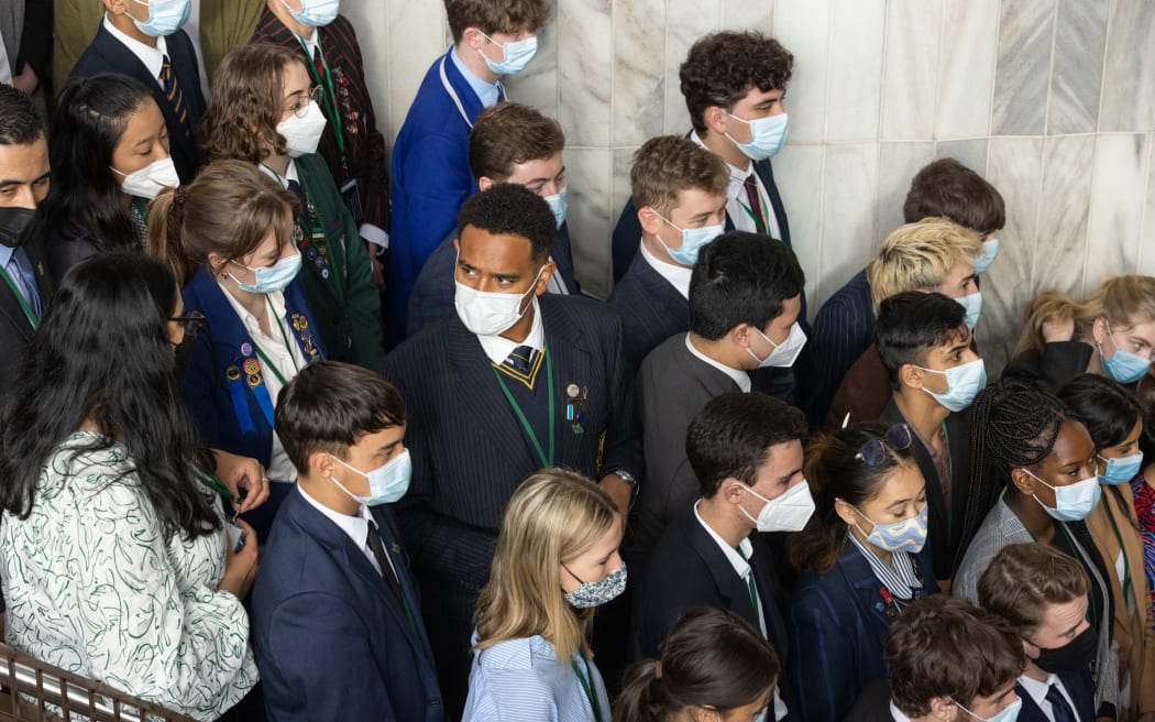 As Youth MPs, Youth Press Gallery and the Youth Clerk assemble on the Beehive staris for a group photo Epeli Ole (Youth MP for Carmel Sepuloni) turns to chat with Sumita Singh (Kiri Allan) - Youth Parliament 2022.