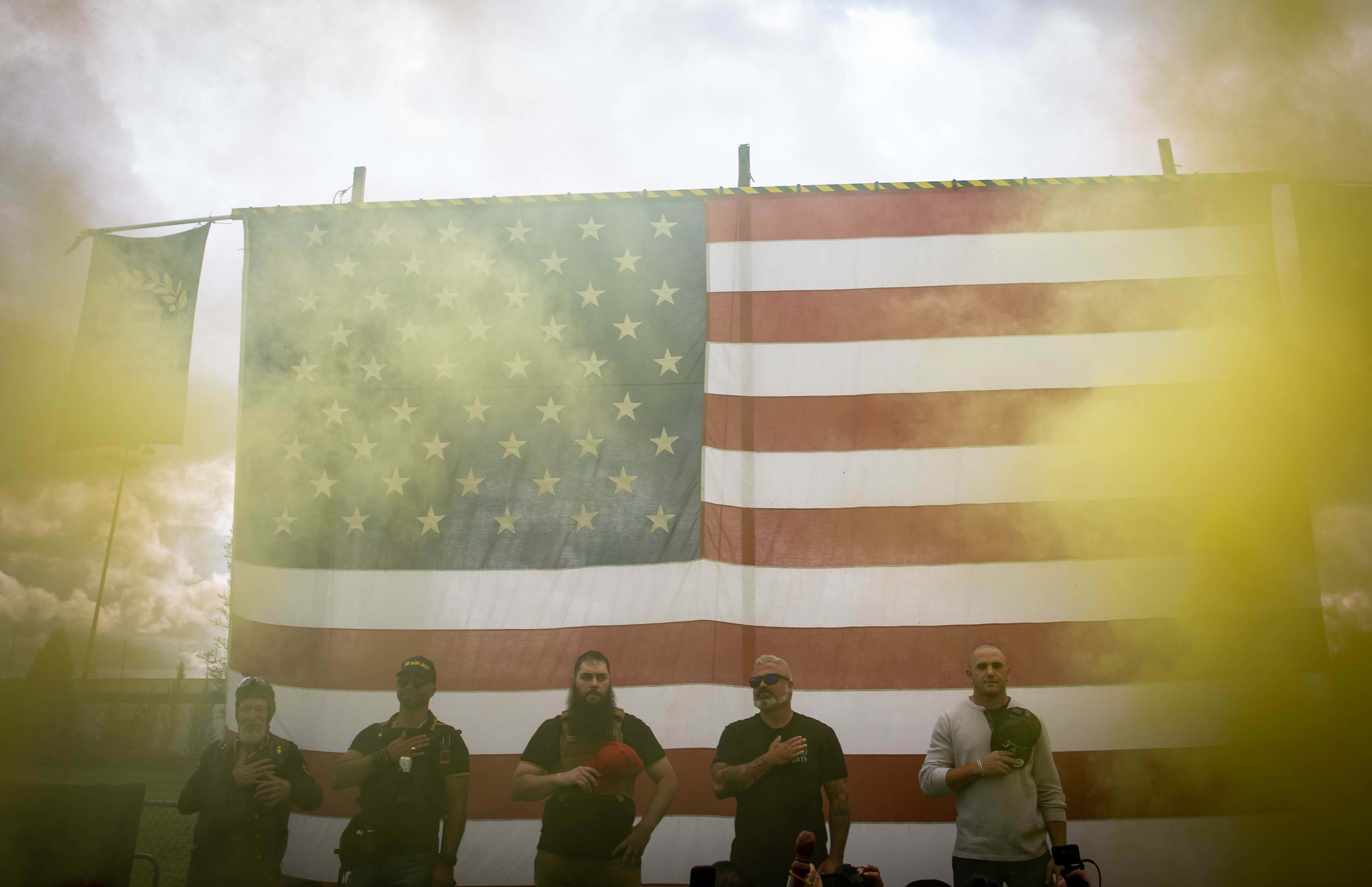 Yellow smoke fills the air as an American flag is raised at the start of a Proud Boys rally at Delta Park in Portland, Oregon on September 26, 2020.