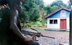 Photo taken on the 20th of July 2003. A militiaman loyal to renegade warlord Harold Keke guards the church where hostages Father Peter Kesimo, Father Alfred Tabo and Father Benjamin Kunu are being held in the Guadalcanal Liberation Front stronghold of Mbiki on the remote Weather Coast.