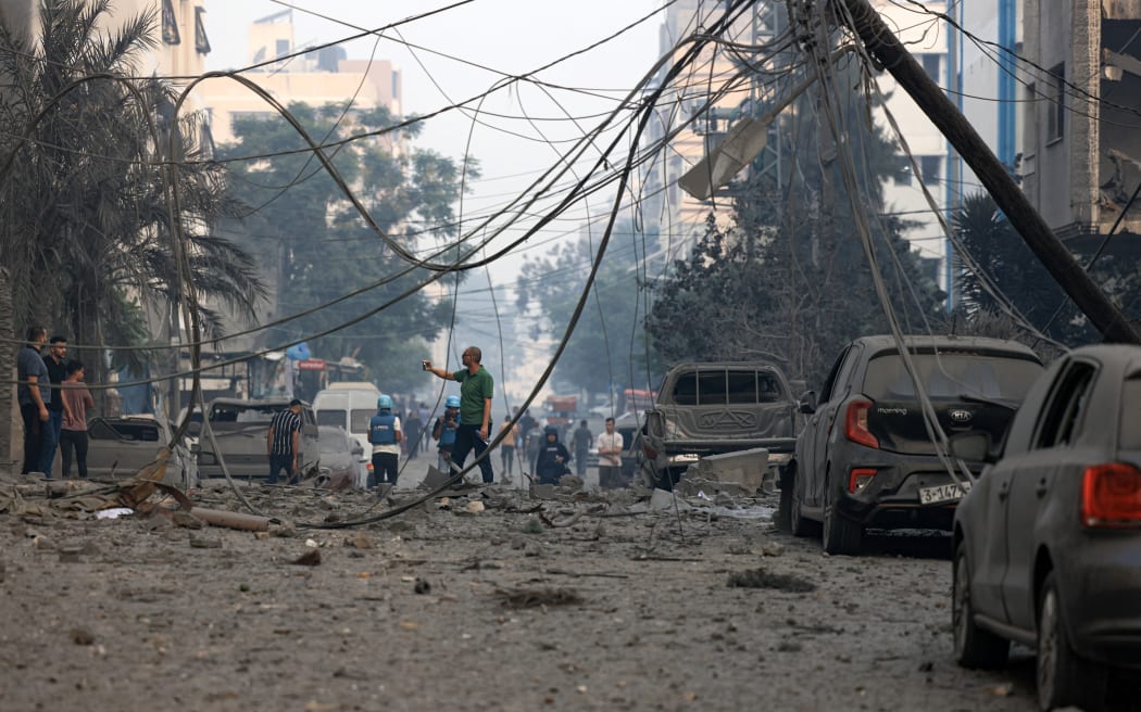 Residents check the damage following Israeli air strikes in Gaza City early on 8 October, 2023.