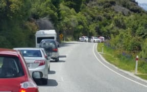 Traffic backs up while the Armed Offenders Squad arrests two people.