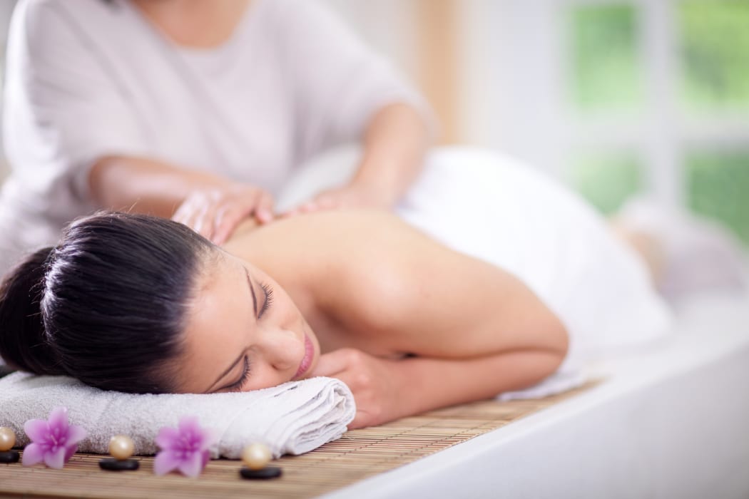 Beautiful woman having a wellness back massage at spa salon