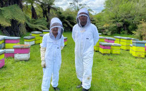 Margaret Bennett (left) and son-in-law and beekeeper James Jeffery (right) stand in their bee suits in the middle of the hives.