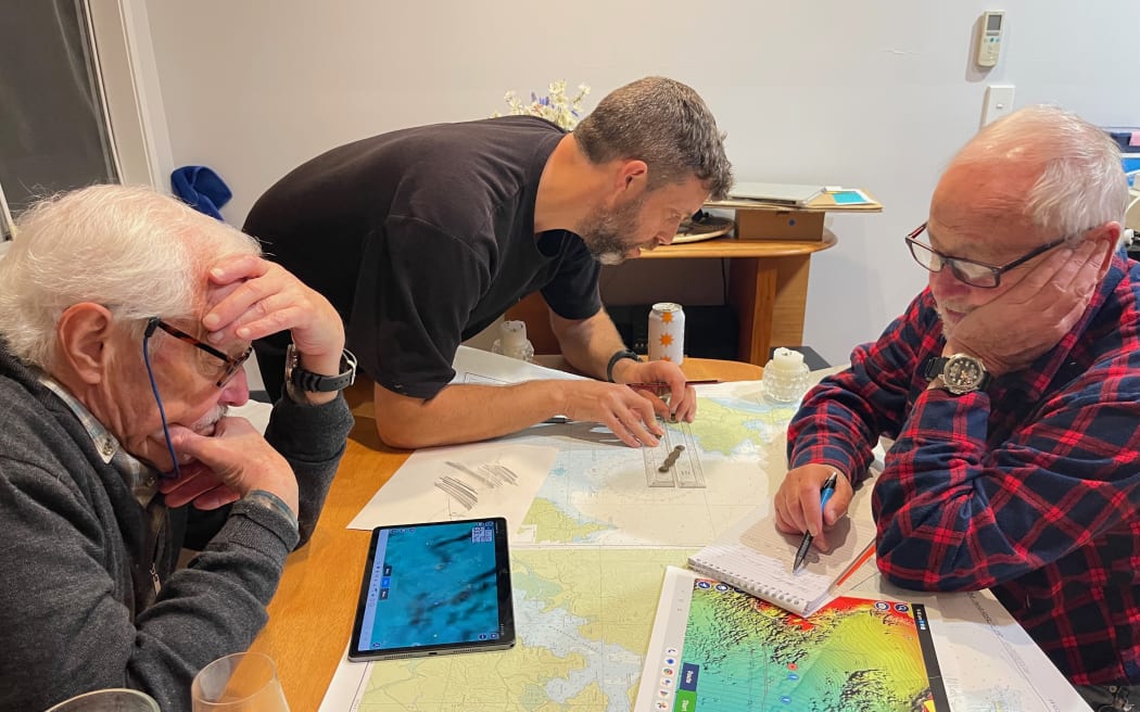 Dave Moran, Brendan Wade and Keith Gordan pour over maps.