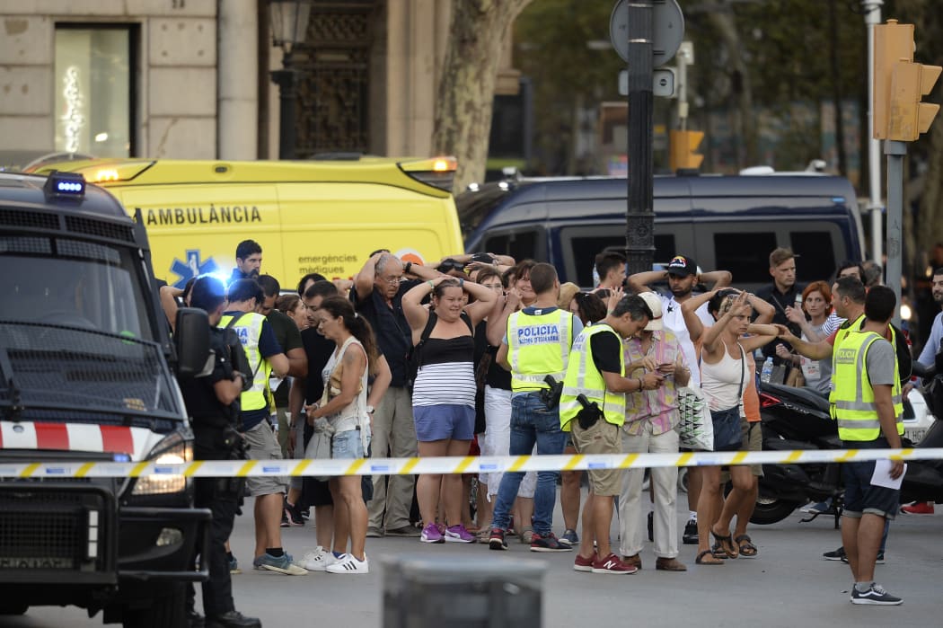 Police check the identity of people after a van ploughed into a crowd in Barcelona.