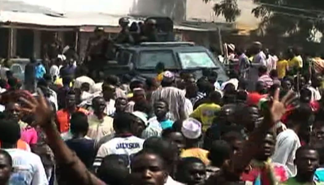 A screen grab taken from a video released by TVC News shows police forces patrolling while residents react after earlier bomb blasts in Maiduguri on 25 November 2014.