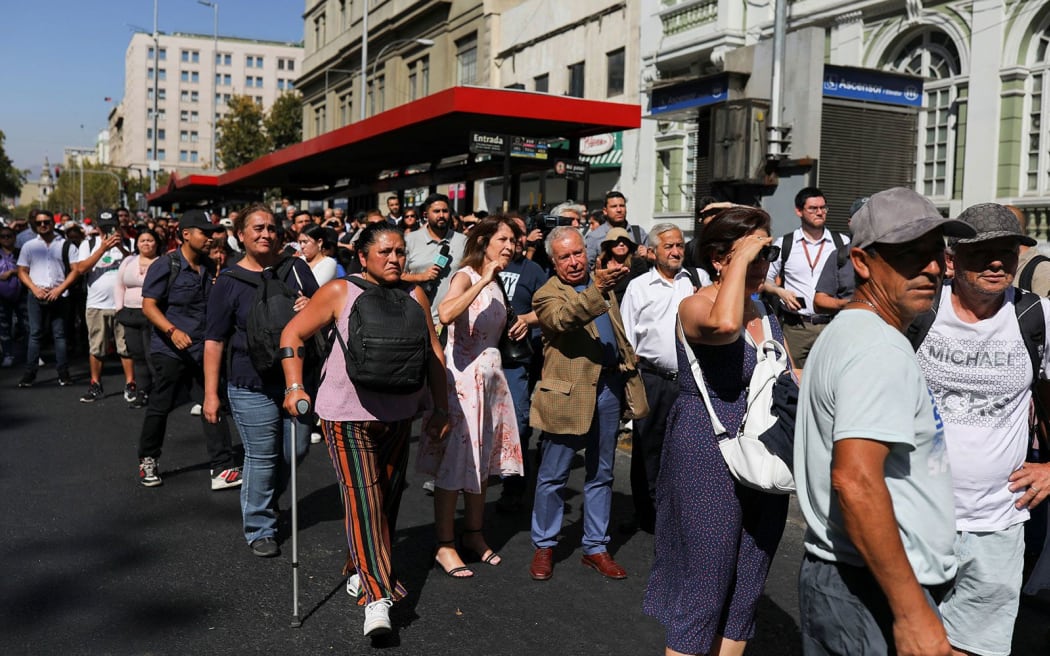 People stand outside buildings after a large power outage struck vast swaths of the country, in Santiago, Chile, on 25 February.  A massive blackout hit Chile on Tuesday including the capital Santiago and its surrounding area.