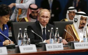 Vladimir Putin (C) looks up as South Korean President Park Geun-hye (L) and Saudi Arabia Crown Prince Salman bin Abdulaziz (R) listen at the start of the plenary session at the G20 Summit.