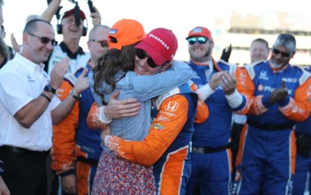 Scott Dixon is hugged by wife Emma after winning the Indycar championship for the fifth time.
