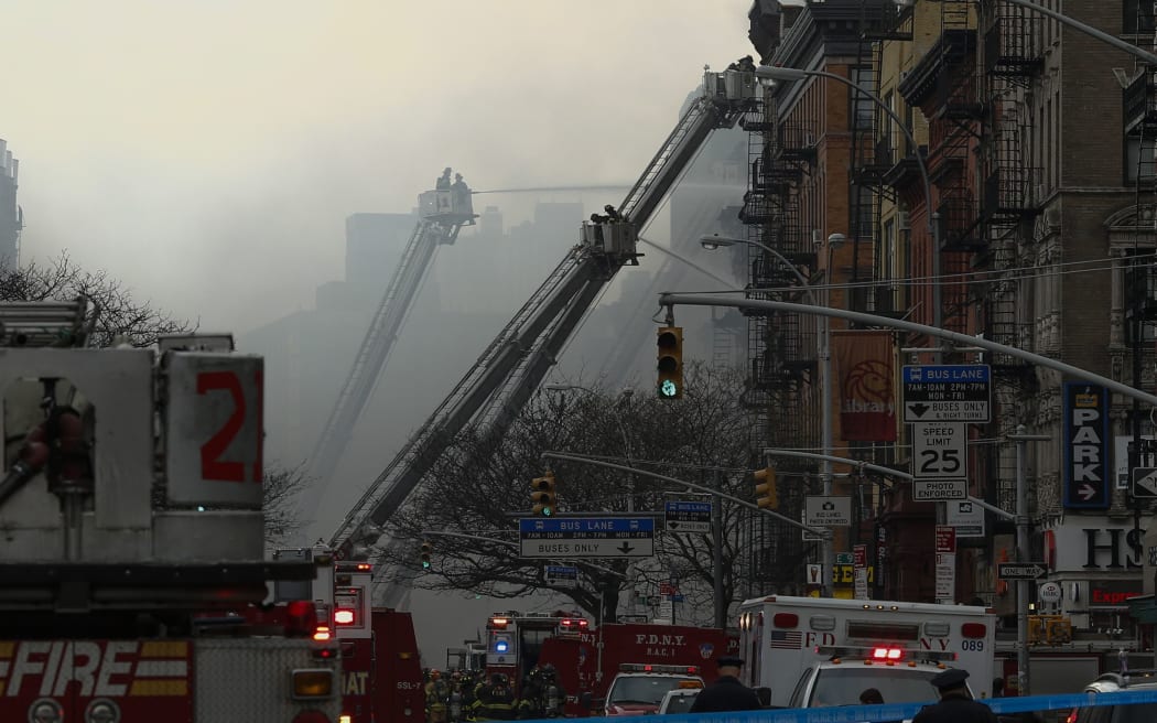 New York firefighters battle a blaze at a commercial and residential block.