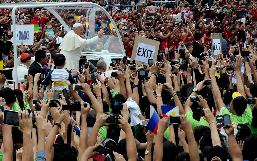 Pope Francis waves to crowds in Manila.
