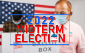 Concept of 2022 Midterm election showing by Man in medical mask placing ballot paper inside the ballot box at polling booth.