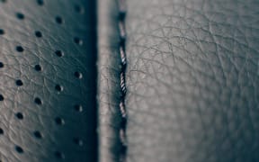 Close up of a detail of the stitches of a car seat in a black handmade leather upholstery.