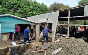 Fijian firefighters and other volunteers help clean out Rawinia Anderson's Esk Valley family home.