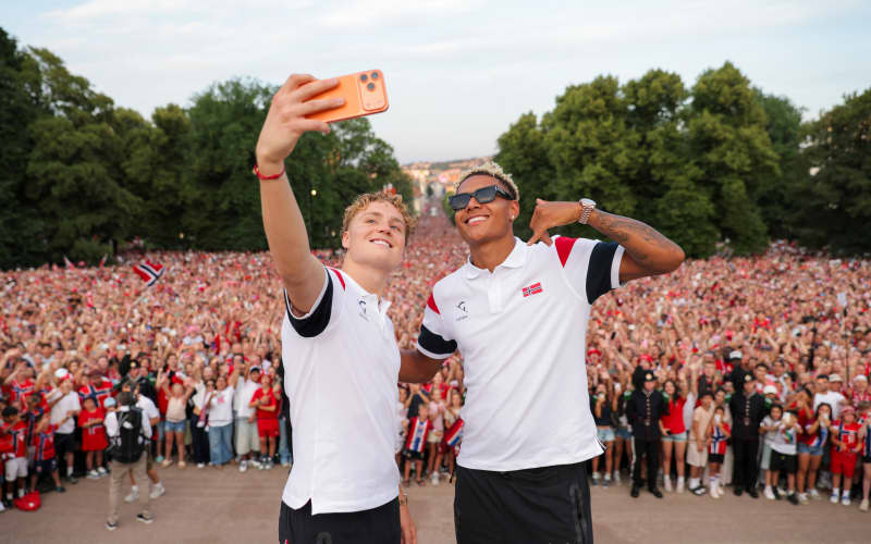 Norway footballers Andreas Schjelderup (L) and Antonio Nusa take a selfie in front of supporters at The Royal Palace after returning from the football World Cup. (Photo: Amanda Pedersen Giske / NTB)