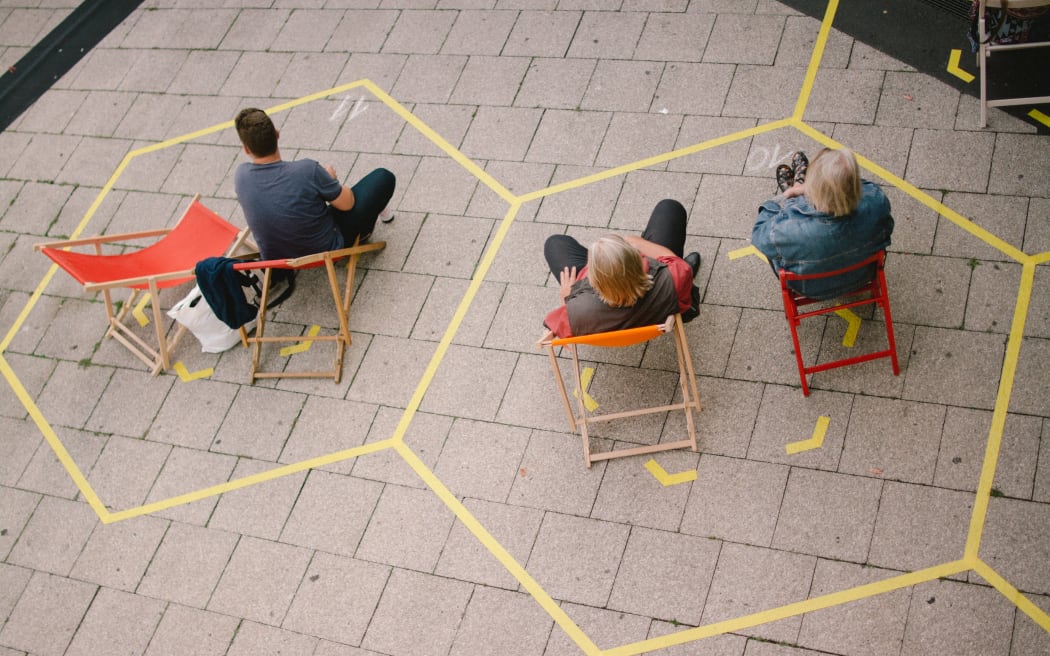 Spectators at an open air concert in Cologne, Germany, sit within social distancing markings on 23 July 2020.