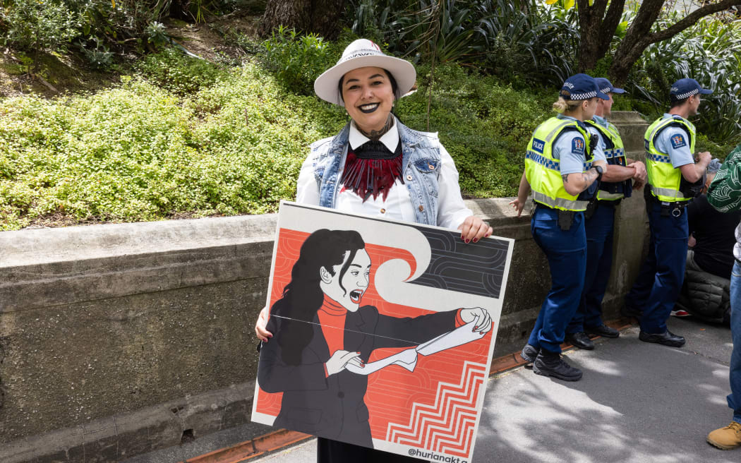 As the hikoi against the Principles of the Treaty of Waitangi Bill reaches Parliament, one participant carries a poster based on an image of Hana-Rāwhiti Maipi-Clarke ripping up the bill immediately before a haka on the floor of the chamber.