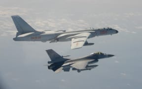 A Taiwanese F-16 fighter jet flying next to a Chinese H-6 bomber (top) in Taiwan's airspace. - Taiwan said it scrambled fighter jets on February 10 after Chinese military aircraft briefly crossed into its airspace.