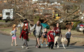 LITTLE ROCK, AR - MARCH 31: A family evacuates their Walnut Ridge neighborhood on March 31, 2023 in Little Rock, Arkansas. Tornados damaged hundreds of homes and buildings Friday afternoon across a large part of Central Arkansas. Governor Sarah Huckabee Sanders declared a state of emergency after the catastrophic storms that hit on Friday afternoon. According to local reports, the storms killed at least three people.   Benjamin Krain/Getty Images/AFP (Photo by Benjamin Krain / GETTY IMAGES NORTH AMERICA / Getty Images via AFP)