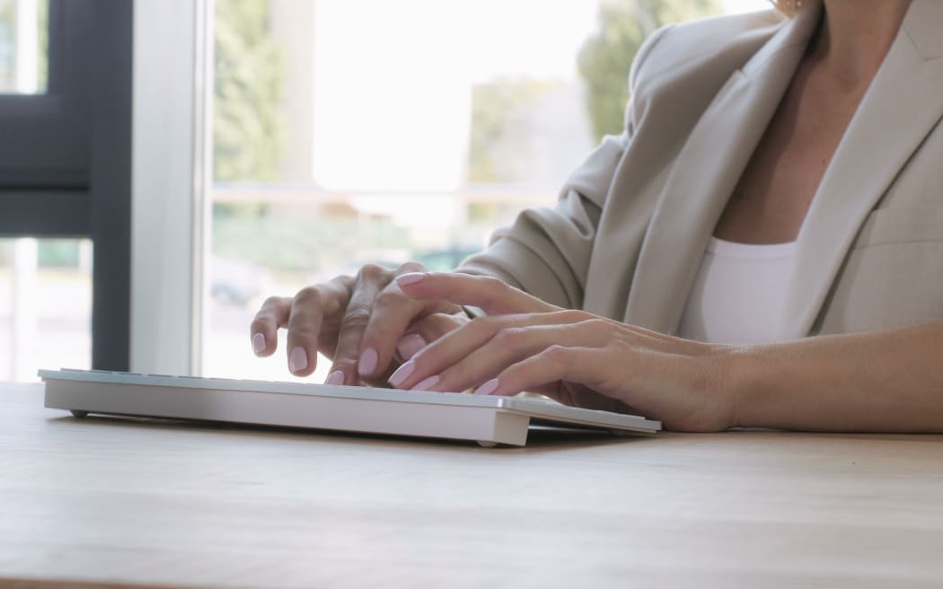 close up details woman typing on white keyboard. Unrecognizable secretary or businesswoman working on computer