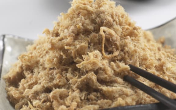 A small plate filled with stringy fluffy meat