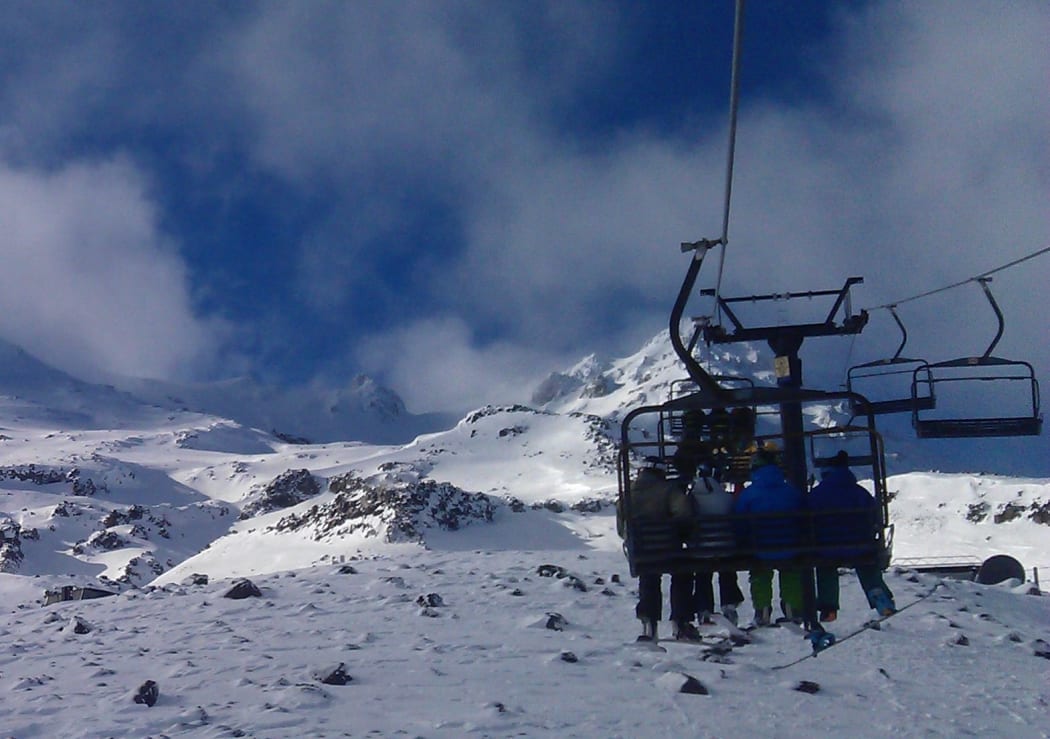 Skiers on a chairlift at Turoa ski field.