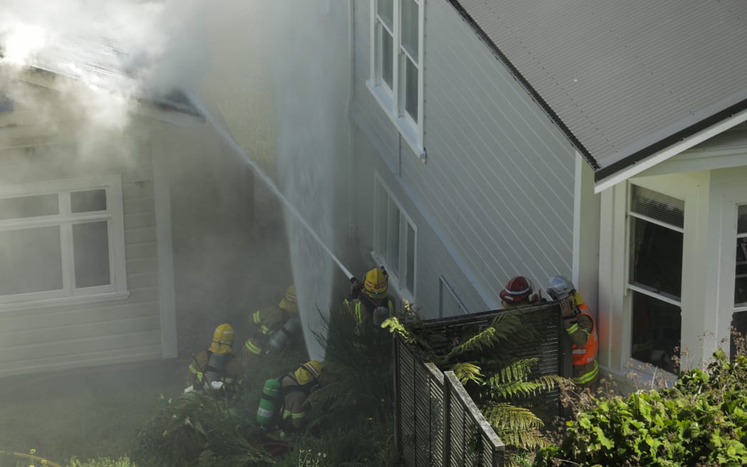 Firefighters protecting a neighbouring house from the fire.