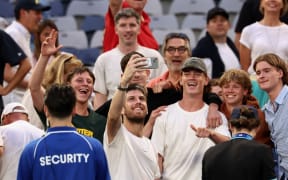 Britain's Cameron Norrie (C) takes a selfie photo with fans as he celebrates after victory against Norway's Casper Ruud in their men's singles match on day seven of the Australian Open tennis tournament in Melbourne on January 20, 2024. (Photo by David GRAY / AFP) / -- IMAGE RESTRICTED TO EDITORIAL USE - STRICTLY NO COMMERCIAL USE --