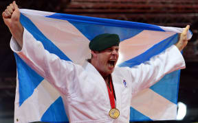 Scotland's gold medalist Christopher Sherrington poses with the Scottish flag at the medal ceremony for the men's judo +100kg class at the SECC Precinct during the 2014 Commonwealth Games in Glasgow.