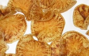 Potato crisps exhibiting Zebra chip disease that caramelises during the cooking process.