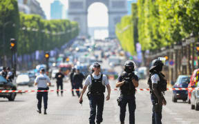 Police patrol the Champs-Elysees after a car crashed into a police van before bursting into flames.