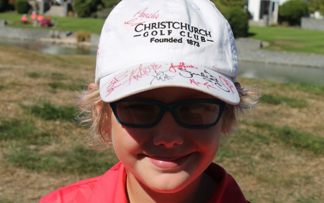 Young golf fan Mica Macdonald shows a hat with signatures including that of Lydia Ko.