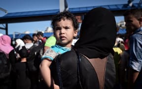 A Syrian child looks on after disembarking from a Greek government-chartered ferry taking refugees from smaller islands, including Leros, to Athens.
