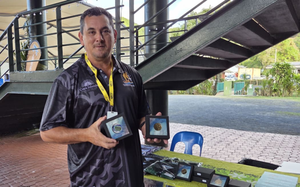 Terry Piri holding special coins marking the big 60th