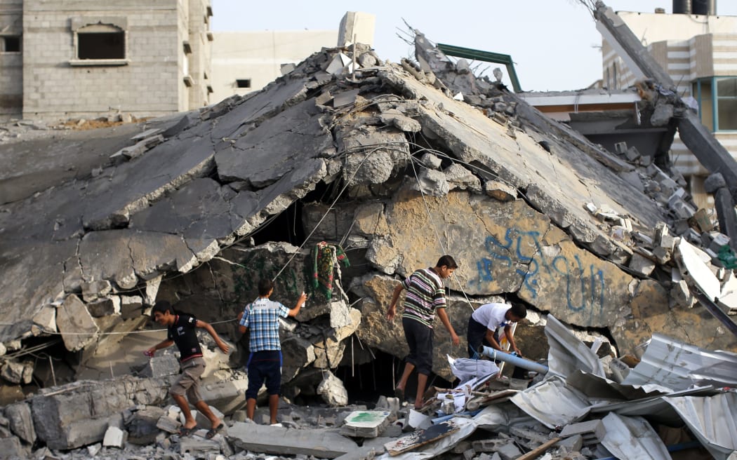 Palestinian men inspect the rubble of a destroyed mosque after an Israeli military strike in the Nusseirat refugee camp in the central Gaza Strip.