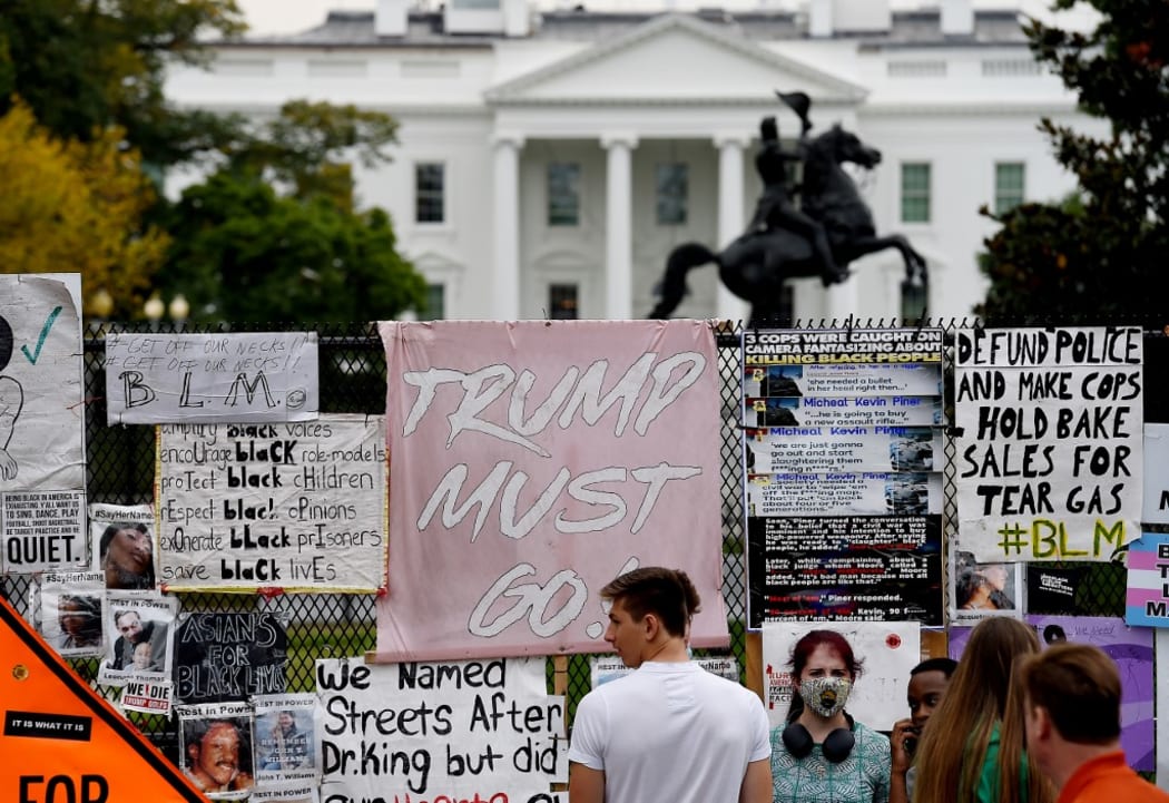 People stand at Black Lives Matter Plaza in Washington, DC, on October 10, 2020, ahead of a speech by US President Donald Trump at the White House.