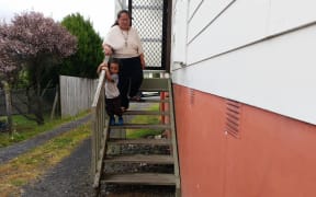Gia Seuseu and her youngest son on the steps of her Glen Eden home.
